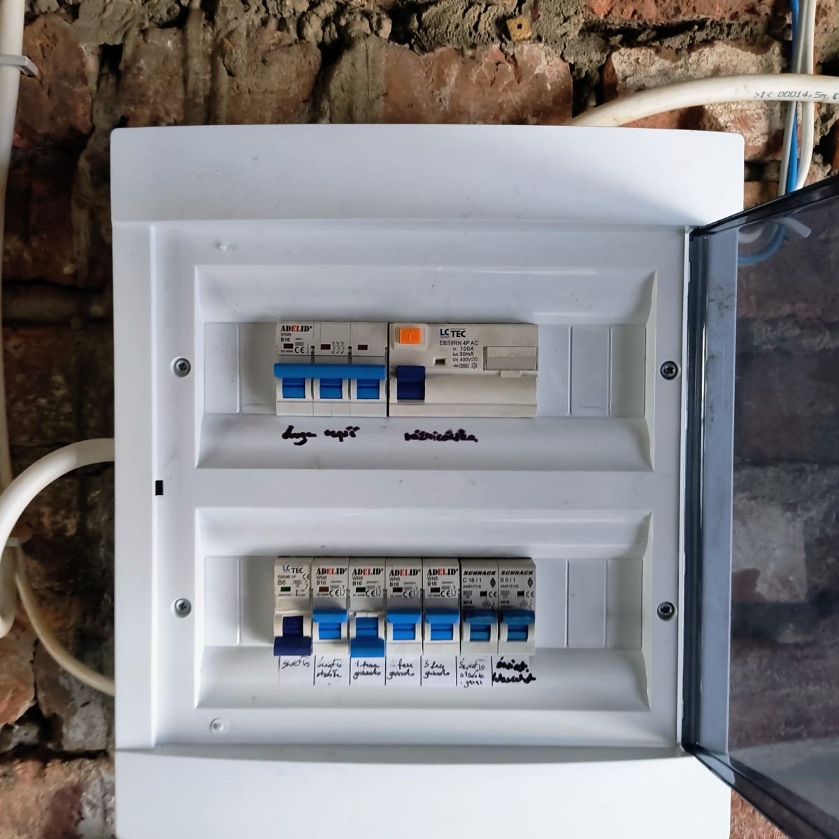 Otwarta rozdzielnia elektryczna wewnątrz budynku, z zabezpieczeniem różnicowoprądowym i opisanymi obwodami